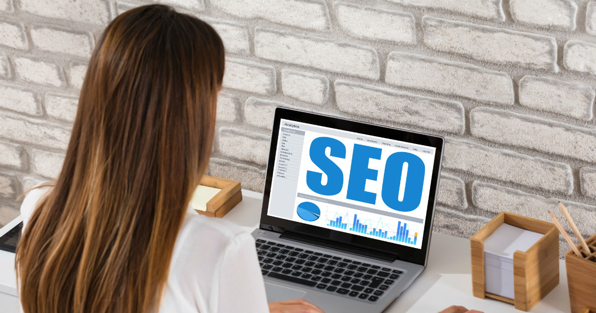 Houston web design service designer working on laptop that says SEO on it.