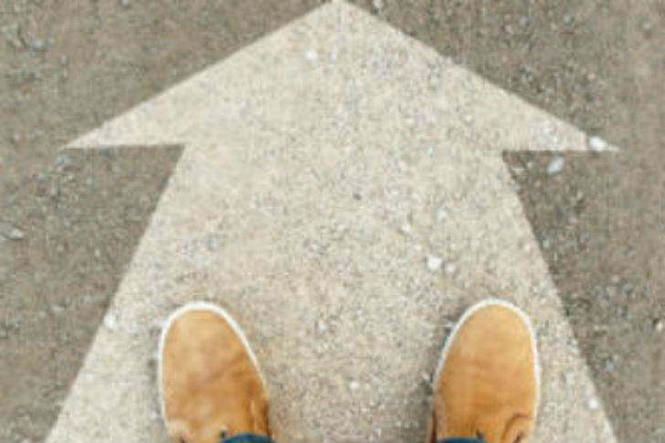 Two feet on arrow in concrete