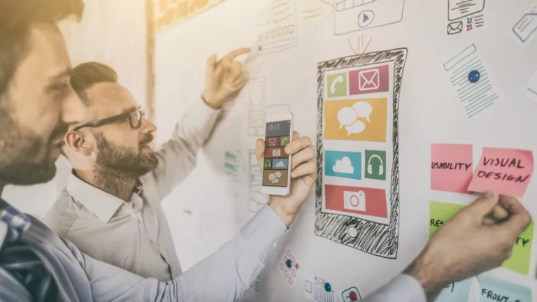 Team of web designers working on white board.