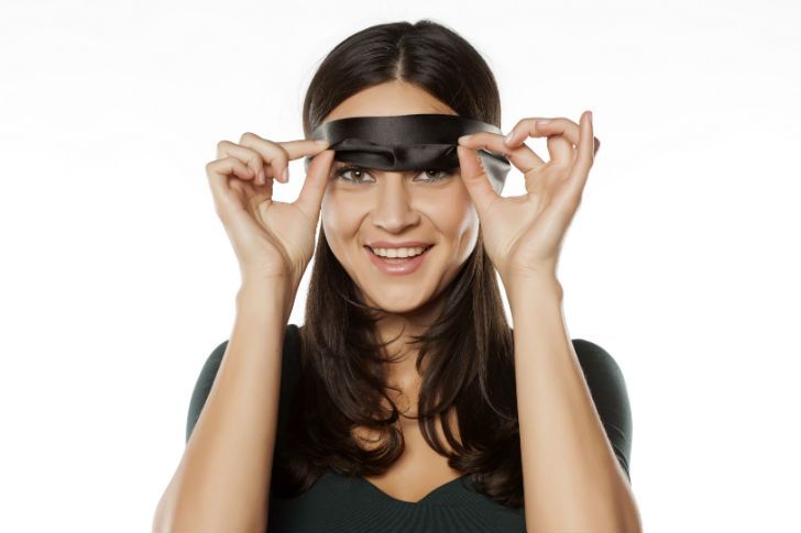 Woman taking off blindfold smiling